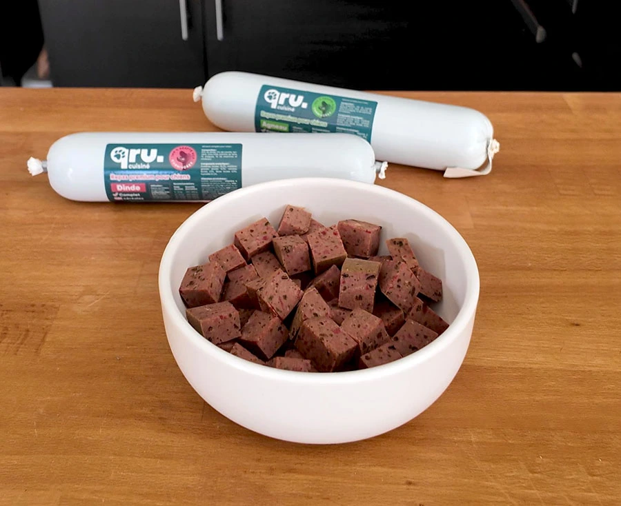Saucisson pour chien sur une table et dans une gamelle